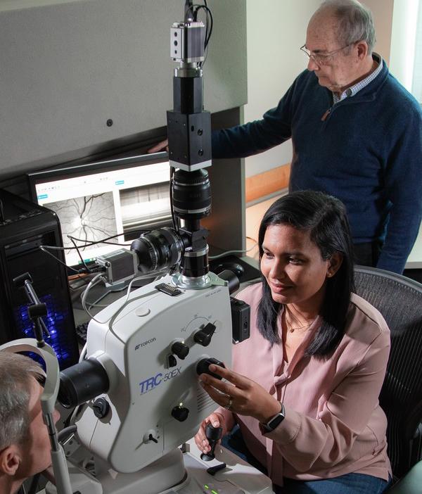 Swati More, Ph.D, and Robert Vince, PhD., assess a patient using the noninvasive retina scan technology they developed